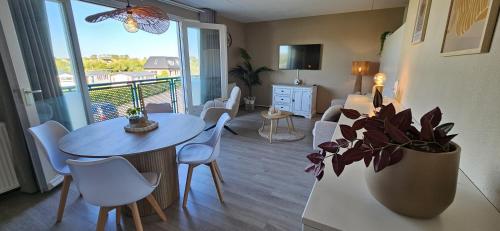 a living room with a table and a balcony at Bon Diaz at Sea in Julianadorp
