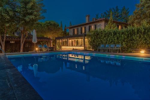 a swimming pool in front of a house at night at Casanova di Pescille in San Gimignano