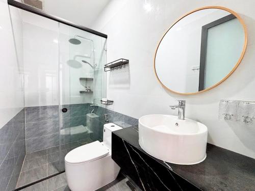 a bathroom with a sink and a toilet and a mirror at ECHO VILLA PHAN THiET in Phan Thiet