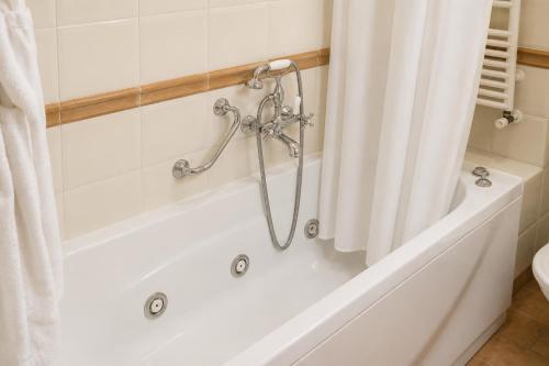 a white bath tub with a shower curtain in a bathroom at Grand Hotel Vigna Nocelli in Lucera