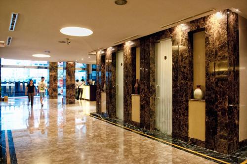 a lobby with people walking in a building at Grand Sakura Hotel in Medan