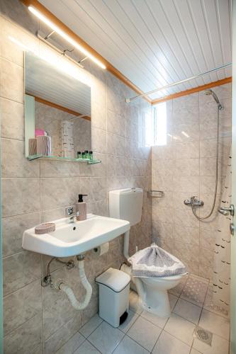 a bathroom with a sink and a toilet and a shower at Malandris Studios in Skala Marion