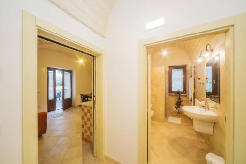 La salle de bains est pourvue d'un lavabo et d'un miroir. dans l'établissement Casa Vacanze a Pauljne, à Locorotondo