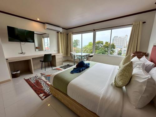 a bedroom with a large bed with a large window at Thipurai Beach Hotel in Hua Hin