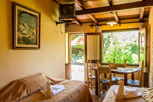 Zimmer mit einem Bett und einem Tisch mit einem TV in der Unterkunft Tico Tico Apart in Mina Clavero