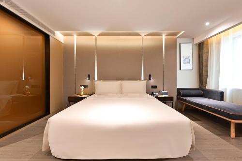 a bedroom with a large white bed and a chair at Atour S Hotel Beijing Anzhen in Beijing