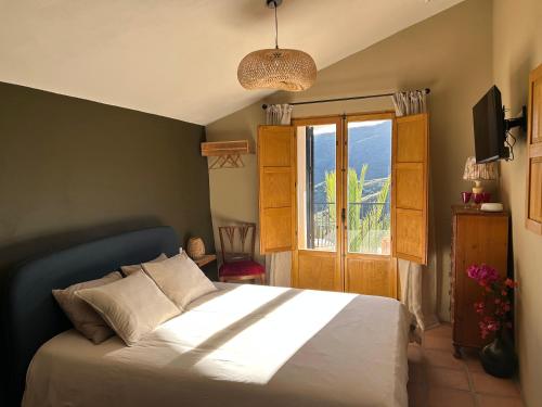 a bedroom with a white bed and a window at Finca RustiQ in Torrox
