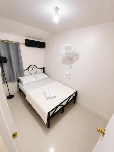a small bedroom with a bed and a fan at Sparrow Transient Townhouse in Davao City