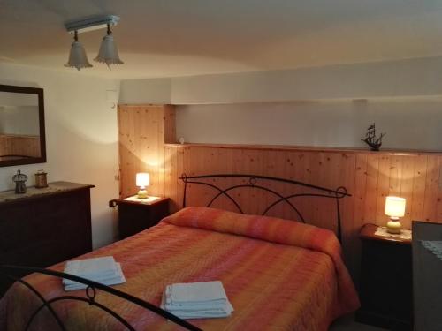 1 dormitorio con 1 cama con 2 lámparas y toallas en B&B La Magnolia, en Sulmona