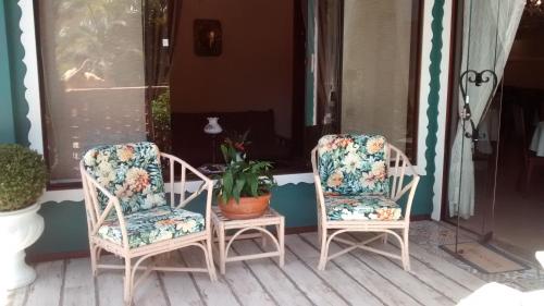 two chairs and a plant on a porch at Edelweiss Pomerode in Pomerode