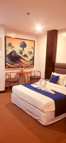 a hotel room with two beds and a table at Huddle Room Drive Inn Motel in Angeles