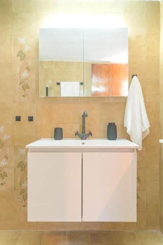 a bathroom with a white sink and a mirror at Aria Seaview Villa in Vourvourou