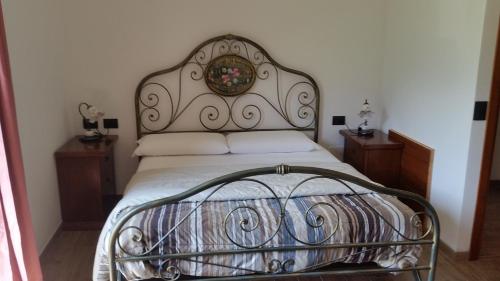 a bed with a metal frame in a bedroom at Agriturismo Nona Rosa in Gravedona