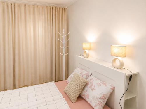 a white bedroom with a bed with two pillows at NDK - Dream House in Sofia