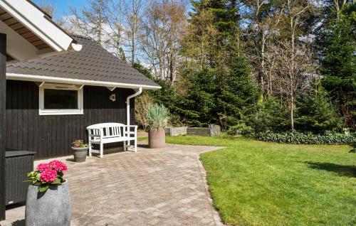 a house with a white bench in a yard at Awesome Home In Ulfborg With Wifi in Ulfborg