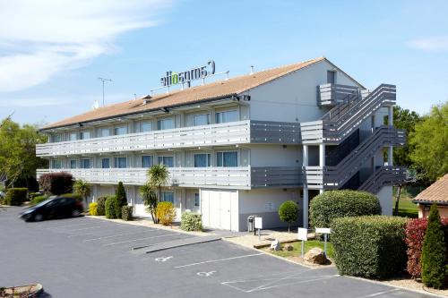 a large white building with a parking lot at Campanile Valenciennes - Petite-Forêt in Petite Forêt