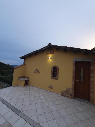 a yellow house with a large patio at Villa Maris in Nebida