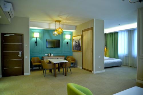 a hotel room with a bed and a table and chairs at GREEN Which Hotel Kokshetau in Kokshetau