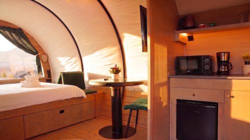 a room with a bed and a table and a microwave at Nomad by Hora cu Brazi in Zărneşti