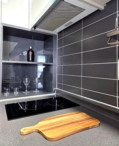 a kitchen with a wooden cutting board on the counter at 썸원호텔 in Yŏsu