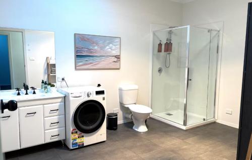 a bathroom with a shower and a washing machine at Roantree House in Portland