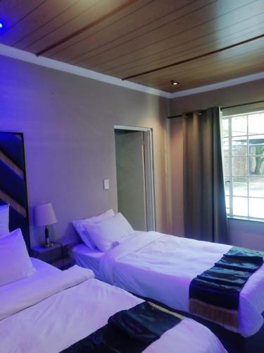 a bedroom with two beds and a window at B&P Guesthouse in Boksburg