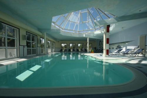 uma grande piscina com um grande tecto de vidro em Treibgut & Surf em Dranske