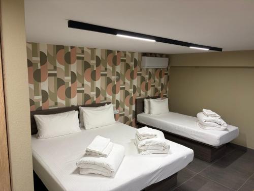 two beds in a room with white towels on them at Tashkent City View Apartments in Tashkent