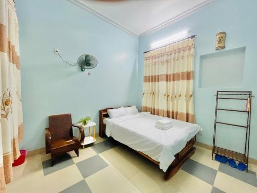 a bedroom with a bed and a chair in it at Hạnh Homestay in Thôn Trị Thủy