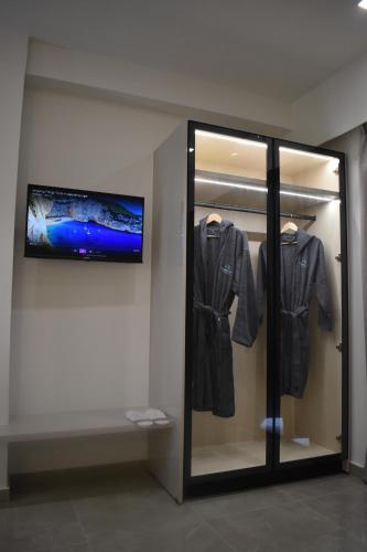 a mirror in a room with a tv and clothes at Olympian Gods apartments in Alikanas