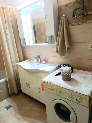 a bathroom with a washing machine and a sink at Maira's place Corfu in Corfu