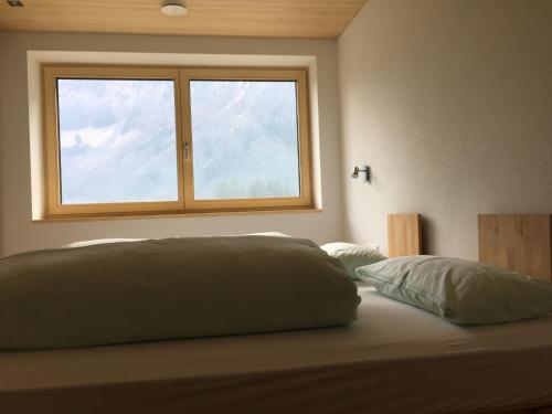 a bedroom with a bed with a window at Haus Katharina in Schnepfau