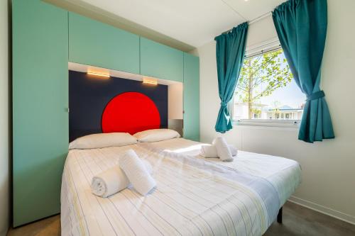 a bedroom with a large bed with a red headboard at Camping Residence & Lodge Orchidea in Baveno