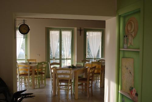 a dining room with tables and chairs and windows at Le Maraclà Country House in Iesi