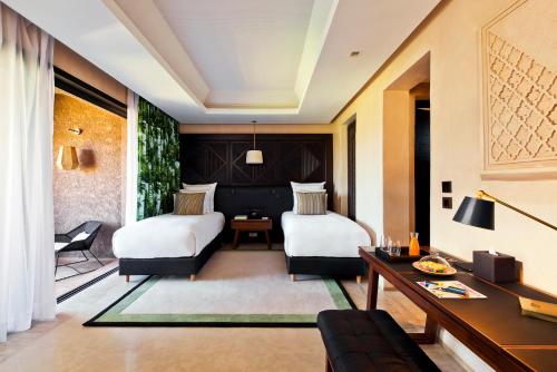 a hotel room with two beds and a desk at Fairmont Royal Palm Marrakech in Marrakech