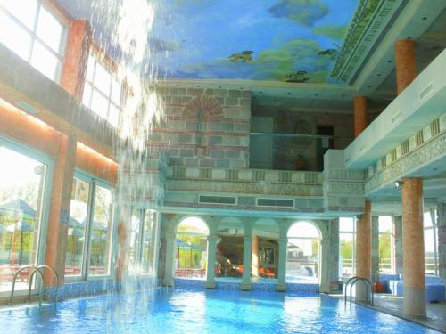 a building with a swimming pool with a painting on the ceiling at Sokoterme Hotel in Soko Banja