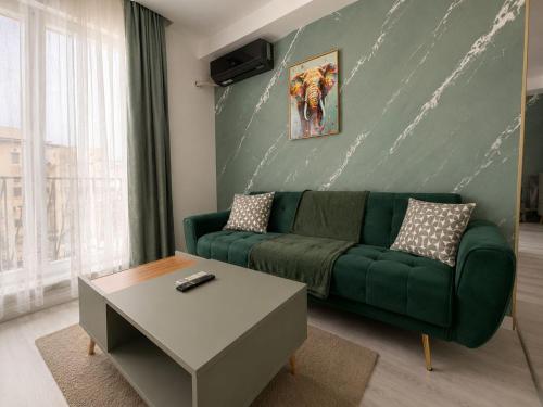 ein Wohnzimmer mit einer grünen Couch und einem Tisch in der Unterkunft Green Place #Cosmopolis #freeparking in Tunari