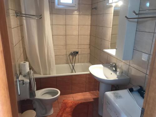 a bathroom with a toilet and a sink and a tub at Theodora villas Portaria beach 2 in Paralia Dionysiou