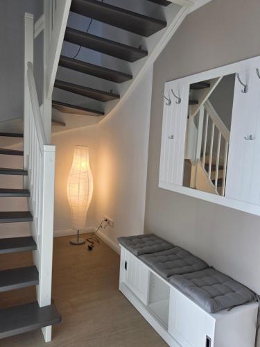 a room with a staircase with a mirror and a lamp at Muttis Haus Auf dem Felde 15 in Ummern