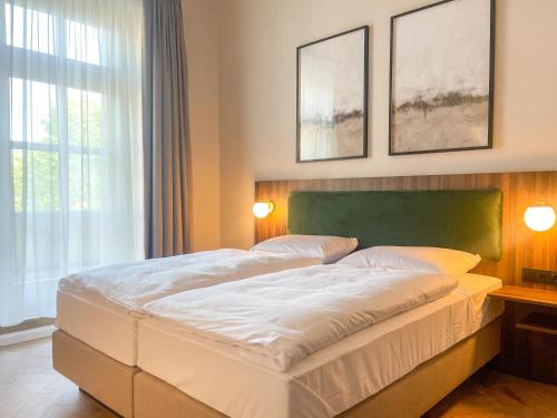 a bedroom with a large white bed with two lamps at Hotel Salina B&B - mit Parkplatz, Zentral und Digital in Bad Rothenfelde
