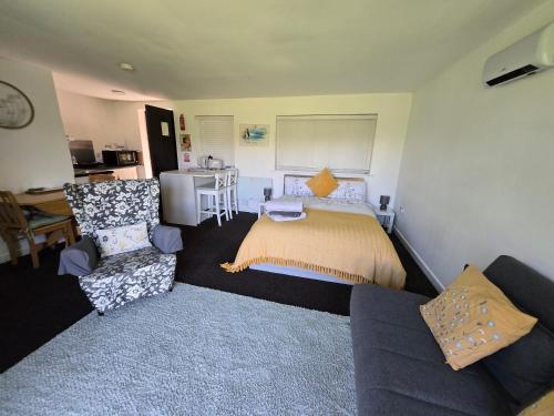 a bedroom with a bed and a couch and a desk at The Piggery - Corfe Mullen in Corfe Mullen