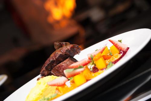 a plate of food with meat and fruit on it at Hotel Jazz Apartments in Bogotá