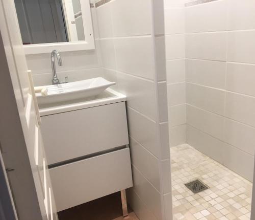a white bathroom with a sink and a shower at Location appartement proche Saint Tropez in Roquebrune-sur-Argens