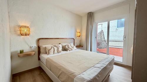 a bedroom with a bed and a large window at Salles Beach 33 in L'Estartit