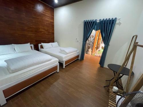 a bedroom with two beds and a window at Old Village House in Yên Bài