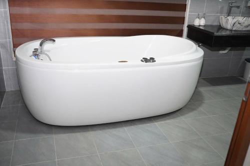 a white bath tub sitting in a bathroom at Old Village House in Yên Bài