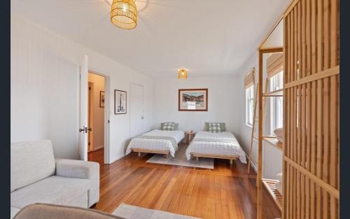 a living room with two beds and a couch at Bungo Beach Shack in Eden