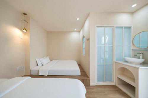 a white bedroom with a bed and a sink at Shanghai WanTing Villa Hotel in Shanghai