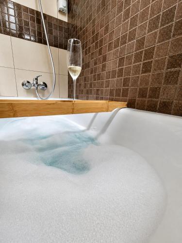 a bath tub with a glass of wine and a glass of water at Casa río de Bolbaite in Bolbaite