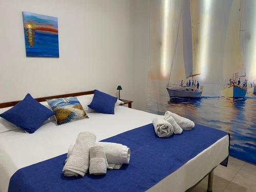 a bedroom with two beds with towels and a sailboat at Vento a poppa in Porto Palo